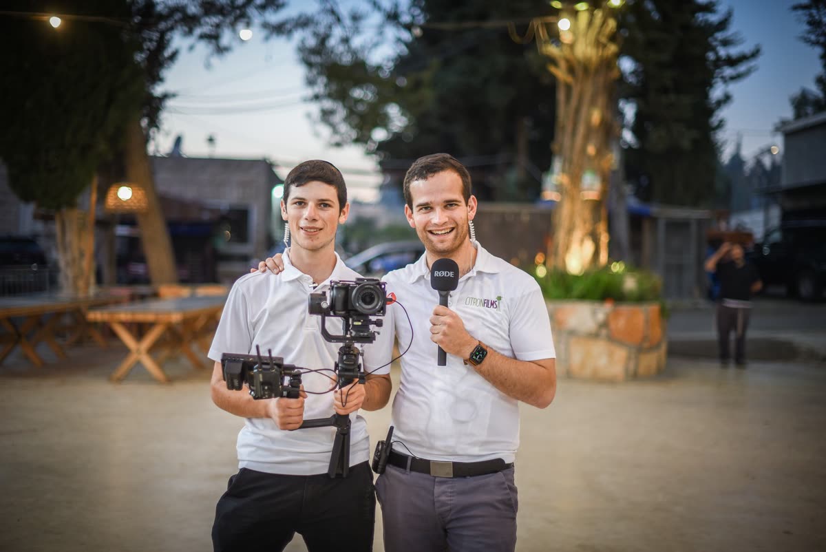 Yaakov with a microphone and a teen with a gimbal