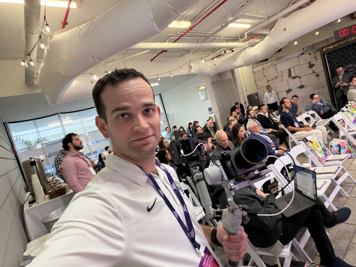 Yaakov with the camera on a gimbal, the audience seated behind him during a talk