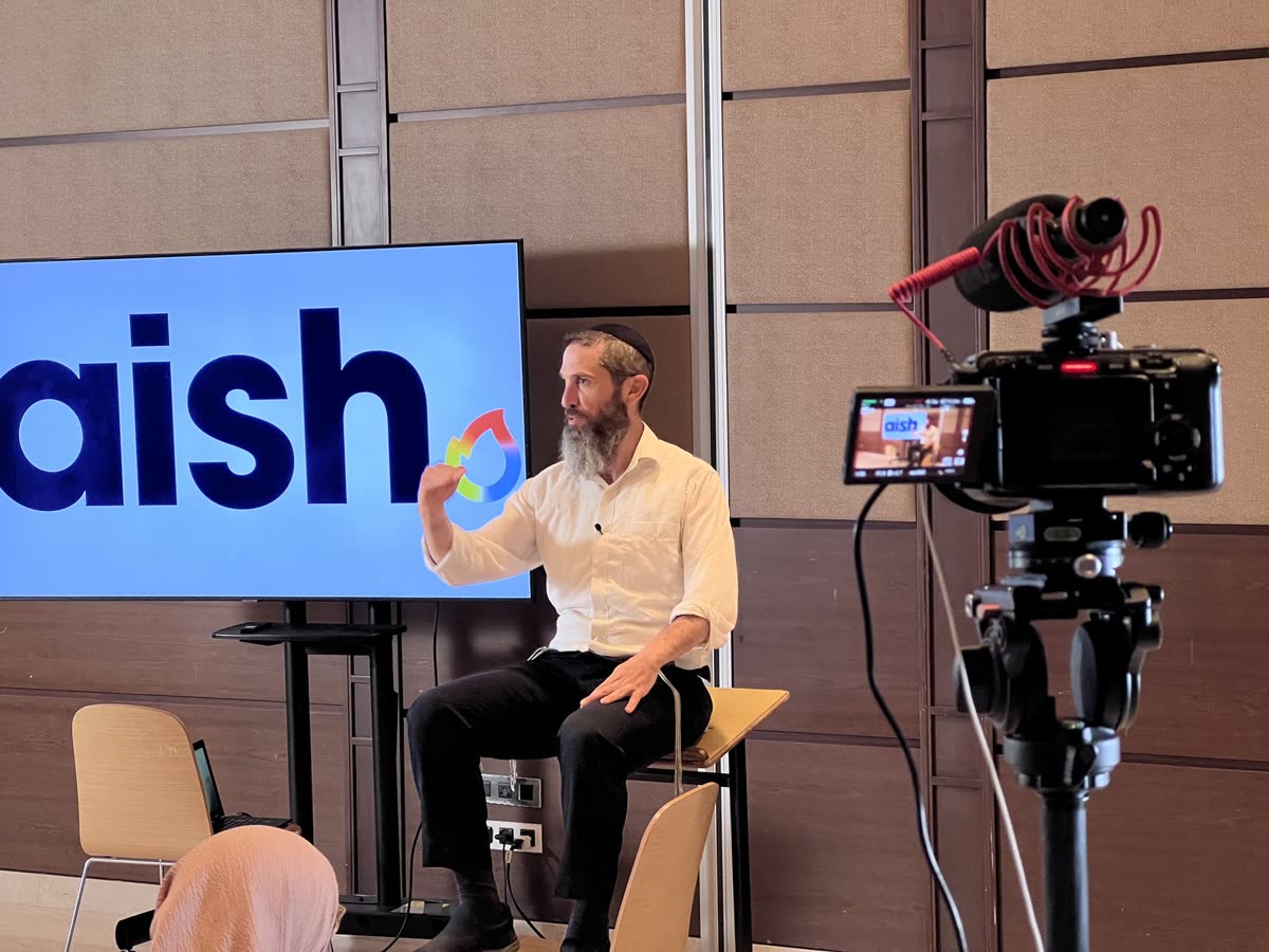 A rabbi speaking on the Aish stage, the camera in front