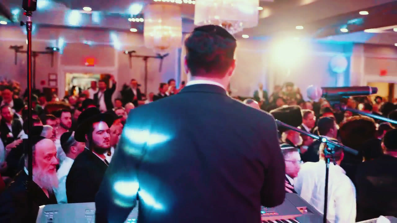 A speaker at a microphone facing a room full of people at an MDY event